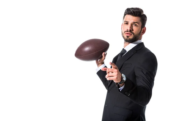 Hombre de negocios en desgaste formal con pelota de rugby señalando con el dedo aislado en blanco - foto de stock
