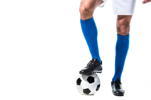 Vista recortada del jugador de fútbol de pie en la pelota aislado en blanco - foto de stock