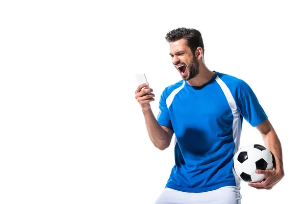 Футболіст з м'ячем кричить і використовує смартфон Ізольовані на білому — стокове фото