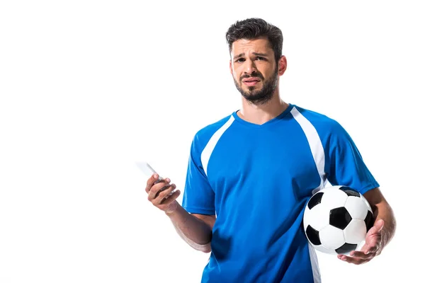 Giocatore di calcio confuso con palla utilizzando smartphone isolato su bianco — Foto stock