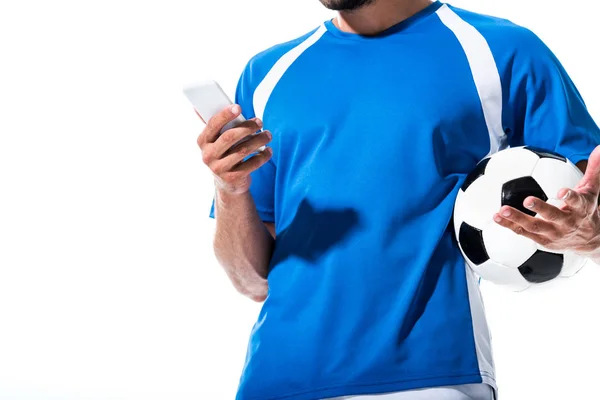 Vue recadrée du joueur de football avec ballon à l'aide d'un smartphone isolé sur blanc — Photo de stock