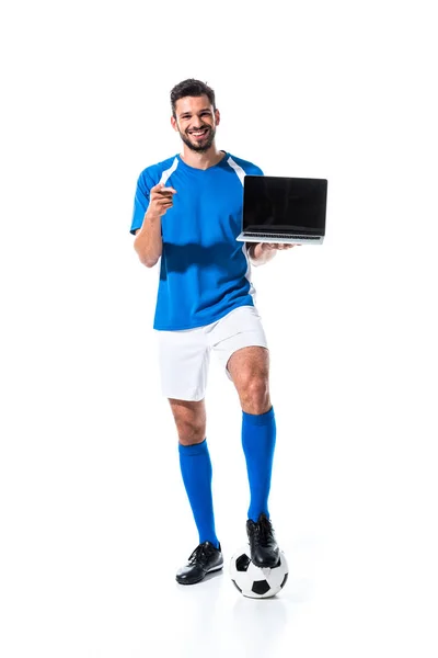 Giocatore di calcio felice con il computer portatile che punta con il dito isolato su bianco — Foto stock