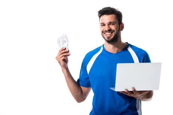 Jugador de fútbol feliz con portátil y billetes de dólar aislado en blanco - foto de stock