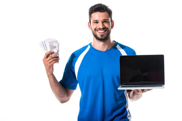 Giocatore di calcio felice con laptop e banconote da un dollaro isolato su bianco — Foto stock