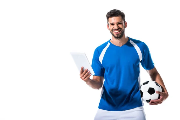 Усміхнений красивий футболіст з м'ячем і цифровим планшетом ізольовано на білому — стокове фото