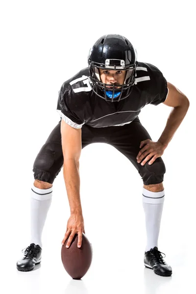 Jugador de fútbol americano sosteniendo la pelota y mirando a la cámara aislado en blanco - foto de stock