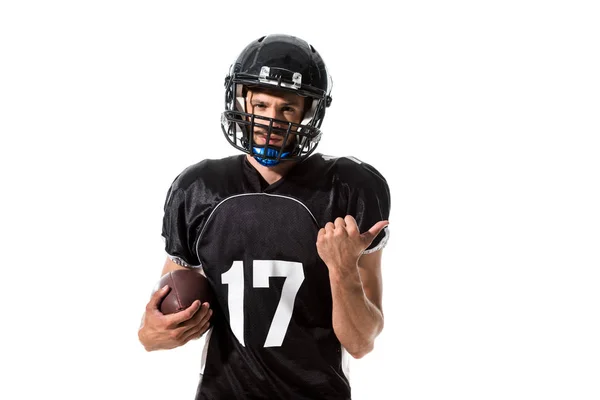 Jugador de fútbol americano sosteniendo la pelota y apuntando con el dedo aislado en blanco - foto de stock