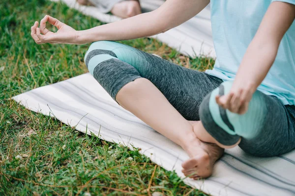 Обрізаний вид жінки і чоловіка, роздумуючи в лотосових позах на килимках йоги — стокове фото
