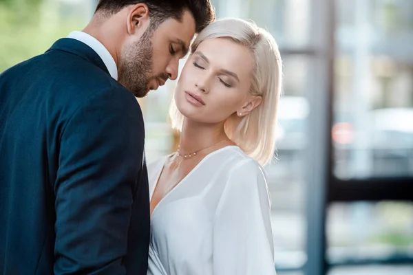 Homme barbu avec les yeux fermés flirter avec belle collègue blonde au bureau — Photo de stock