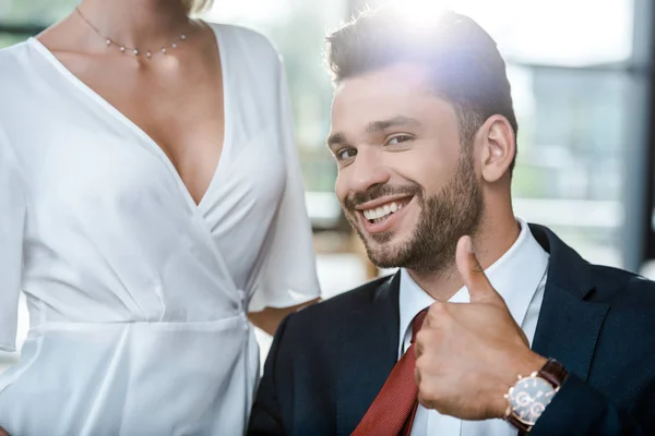 Cropped view of woman near cheerful businessman showing thumb up — Stock Photo