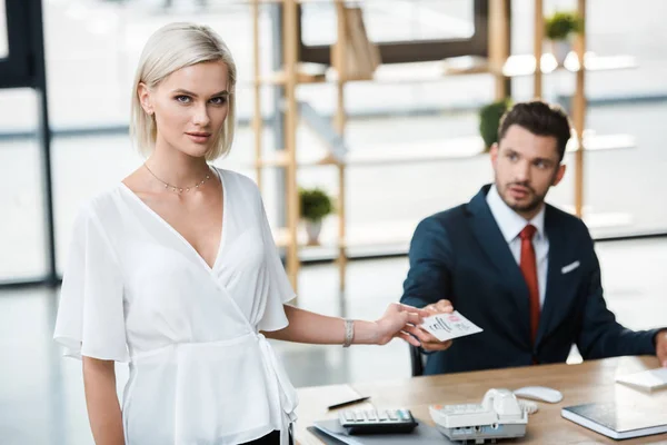 Selective focus of attractive businesswoman holding card call me lettering near handsome businessman — Stock Photo