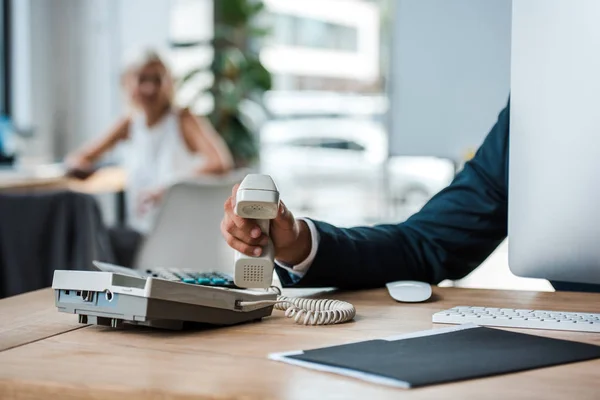 Vista recortada del hombre de negocios con teléfono retro en la oficina - foto de stock