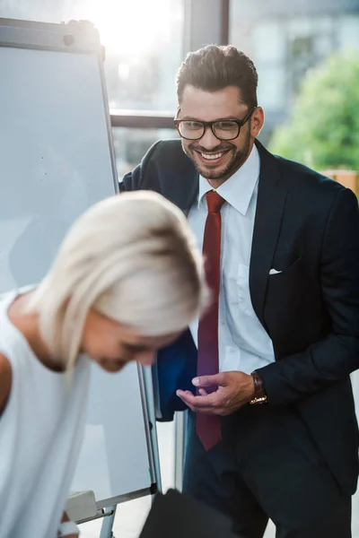 Веселий бізнесмен в окулярах посміхається біля щасливої блондинки — стокове фото