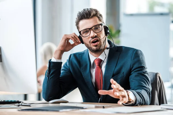 Selektive Fokussierung des bärtigen Geschäftsmannes in Headset-Gesten im Amt — Stockfoto