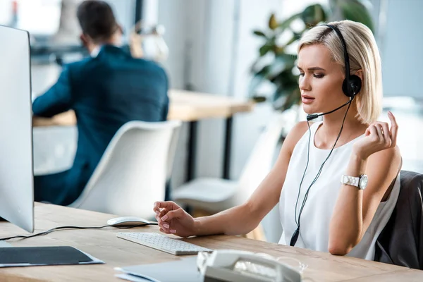 Selective focus of attractive operator in headset working in office — Stock Photo