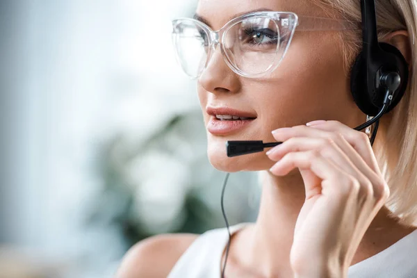 Nahaufnahme der attraktiven blonden Bedienerin mit Brille, die das Headset berührt — Stockfoto