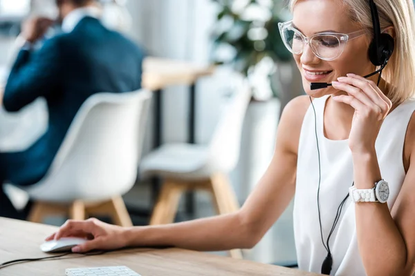 Selektiver Fokus der fröhlichen Blondine, die während ihrer Arbeit im Büro spricht — Stockfoto