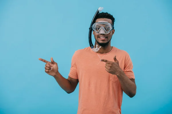 Positive african american man in diving mask pointing with fingers isolated on blue — Stock Photo