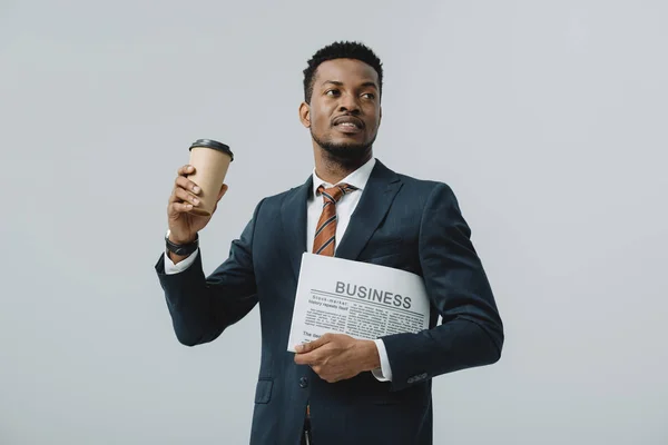 Афроамериканець бізнесмен тримає паперовий стаканчик і ділова газета ізольований на сірий — стокове фото