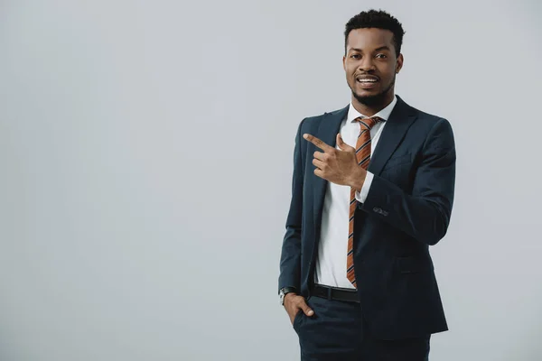 Heureux homme afro-américain pointant avec le doigt isolé sur gris — Photo de stock