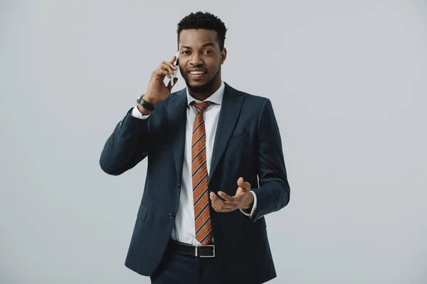 Heureux homme d'affaires afro-américain parlant sur smartphone isolé sur gris — Photo de stock