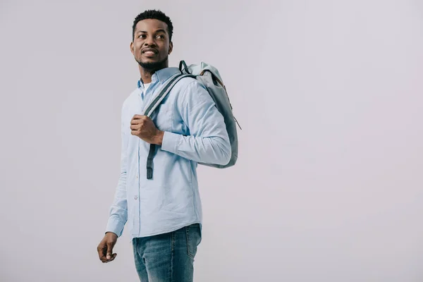 Homem americano africano alegre de pé com mochila isolada em cinza — Fotografia de Stock