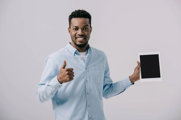 Homem americano africano feliz mostrando polegar para cima e segurando tablet digital com tela em branco isolado em cinza — Fotografia de Stock