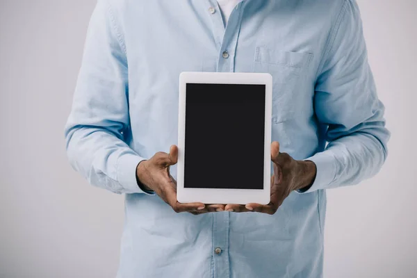 Abgeschnittene Ansicht eines afrikanisch-amerikanischen Mannes, der ein digitales Tablet mit leerem Bildschirm hält, isoliert auf grau — Stockfoto