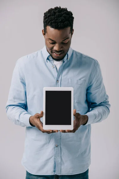 Homme afro-américain joyeux tenant tablette numérique avec écran blanc isolé sur gris — Photo de stock