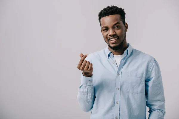 Cheerful african american man showing heart shape gesture isolated on grey — Stock Photo