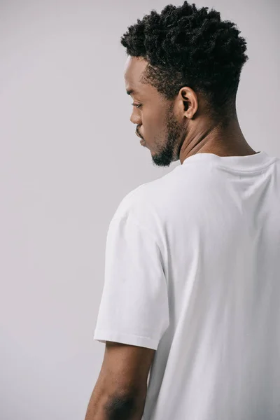 Bel homme afro-américain en t-shirt blanc isolé sur gris — Photo de stock