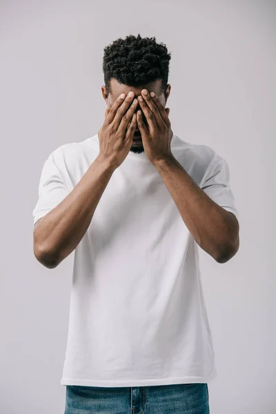 Homme afro-américain couvrant le visage avec les mains isolées sur gris — Photo de stock