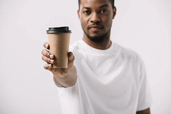 Selective focus of african american man holding paper cup isolated on white — Stock Photo