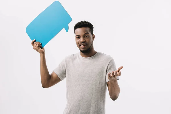 Щасливий афроамериканський чоловік тримає синю бульбашку мовлення і жестикулює ізольовано на білому — стокове фото