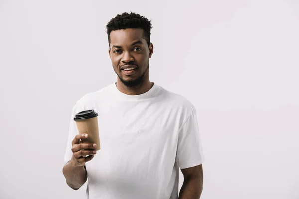 Encaracolado e feliz afro-americano homem segurando copo de papel isolado no branco — Fotografia de Stock