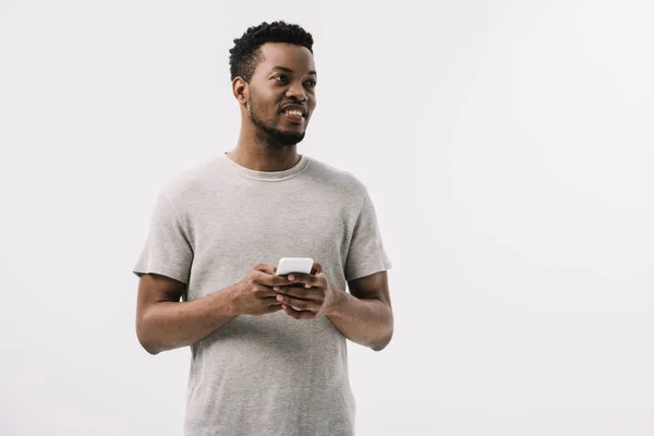 Homem americano africano feliz e encaracolado usando smartphone isolado no branco — Fotografia de Stock