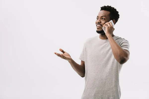 Hombre afroamericano feliz gesto mientras habla en el teléfono inteligente aislado en blanco - foto de stock