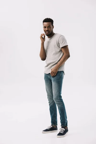 Напряженный африканский американец в серой футболке изолирован на белом — стоковое фото