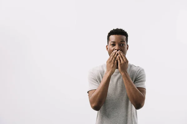Afro-américain homme couvrant la bouche et regardant caméra isolé sur blanc — Photo de stock