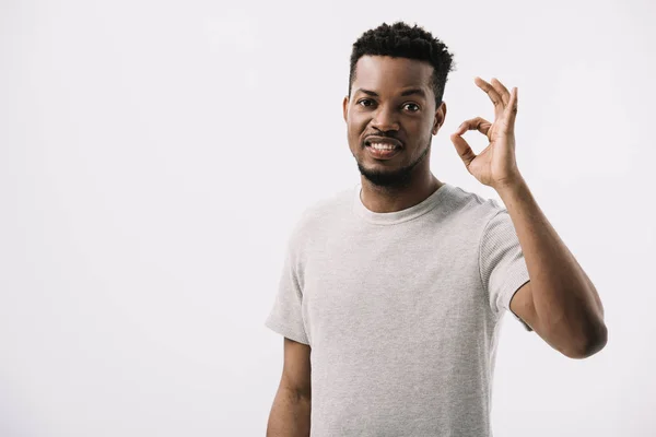 Positive african american man showing ok sign while looking at camera isolated on white — Stock Photo