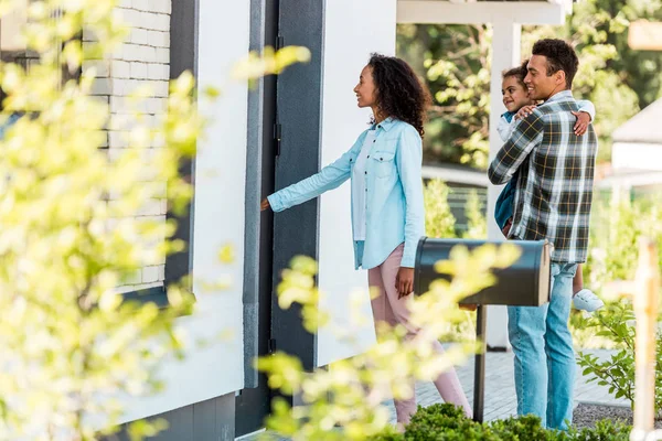 Foyer sélectif de la famille afro-américaine entrant dans une nouvelle maison tandis que le père tenant enfant — Photo de stock