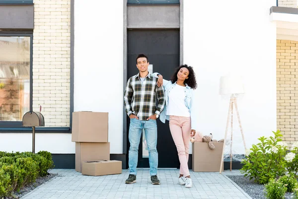 Full length view of african american wife leaning on man while looking at camera — Stock Photo