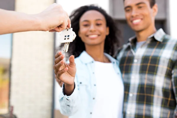 Enfoque selectivo de la pareja afroamericana sonriendo mientras toma la llave de la nueva casa - foto de stock