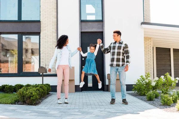 Full length view of african american couple smiling while holding hands with kid — Stock Photo