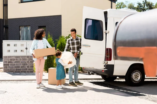 Full length view of african american parents standing near car and looking at kid — Stock Photo