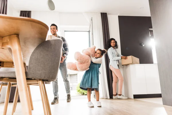 Low angle view of african american family walking into house while holding different stuff — Stock Photo
