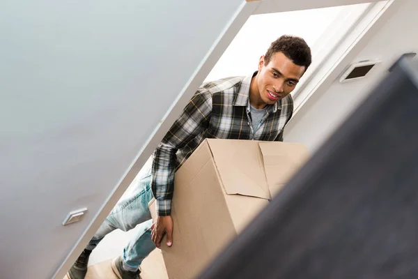 Selektiver Fokus des afrikanisch-amerikanischen Mannes, der Schachtel hält und wegschaut — Stockfoto