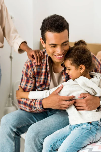 Abgeschnittene Ansicht einer Frau, die den Halter eines afrikanisch-amerikanischen Mannes berührt, während Papa Tochter umarmt — Stockfoto