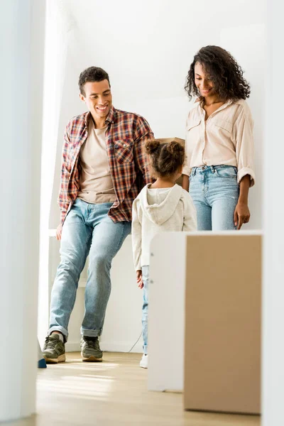 Full length view of african american couple looking at daughter while kid standing near mom and dad — Stock Photo