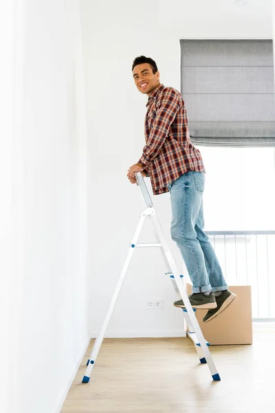 Visão de comprimento total do homem americano africano em pé na escada e olhando para a câmera — Fotografia de Stock